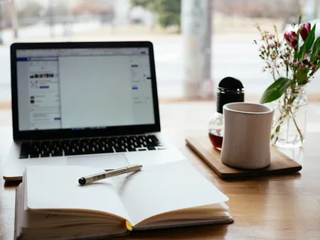 لابتوب وكتاب مفتوح على مكتب